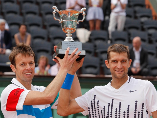 Max Mirnyi of Belarus, left, and Daniel Nestor of Canada, right, hold the trophy after defeating Juan Sebatian Cabal of Colombia and Eduardo Schwank of Argentina in the men's doubles final of the French Open tennis tournament in Roland Garros stadium in Paris, Saturday June 4, 2011. (AP Photo/Lionel Cironneau)