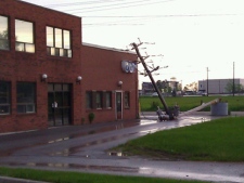 A snapped hydro pole rests against a building near Midland Avenue and McNicoll Avenue after a thunderstorm Tuesday, June 7, 2011. (CP24/Tom Stefanac)
