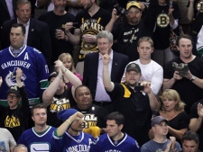 Prime Minister Stephen Harper, centre, attends game 4 of NHL Stanley Cup Final hockey action between Vancouver Canucks and Boston Bruins at the TD Garden in Boston on Wednesday, June 8, 2011. THE CANADIAN PRESS/Jonathan Hayward