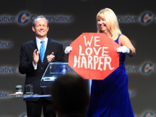 As former Conservative Minister Stockwell Day looks on his wife Valerie Day displays a message for Prime Minister Stephen Harper during the opening the Conservative convention Thursday June 9, 2011 in Ottawa. THE CANADIAN PRESS/Fred Chartrand