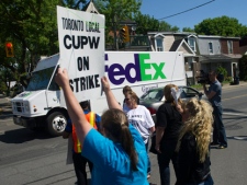 Striking Canada Post workers would not let their competition, FedEx, enter the street as they walked the picket line at a Canada Post sorting plant in Toronto on Tuesday, June 14, 2011. (THE CANADIAN PRESS/Nathan Denette)