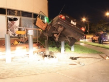 A car was suspended in the air by a concrete pillar after it veered off the road, struck a pole and then the side of a dental office at Ellesmere and Brimley roads early Wednesday, June 15, 2011. (CP24/Tom Stefanac)