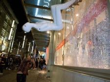 A rioter throws a mannequin at a Granville Street shop following Game 7 of the NHL Stanley Cup final in downtown Vancouver, B.C., on Wednesday, June 15, 2011. (THE CANADIAN PRESS/Geoff Howe)