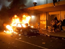 A car burns outside The Bay department store during a riot in downtown Vancouver, B.C., Wednesday, June 15, 2011 following the Vancouver Canucks' 4-0 loss to the Boston Bruins in Game 7 of the Stanley Cup hockey final. (THE CANADIAN PRESS/Ryan Remiorz)