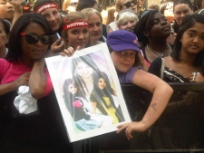 Sarah, 8, holds up a picture of MMVA host Selena Gomez while waiting for the big show to start Sunday. (Sandie Benitah/CP24.com)