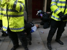 In this April 1, 2009 file photo newspaper seller Ian Tomlinson, is shielded by police, as he receives treatment from police medics, during a anti-G20 demonstration in London. (AP Photo/Akira Suemori, File )