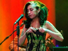 In this image taken Saturday, June 18, 2011 British singer Amy Winehouse performs on stage during her concert in Belgrade Serbia. Winehouse was booed and jeered during a concert in Serbia's capital as she stumbled onto the stage, mumbled through her songs and wandered off. (AP Photo)