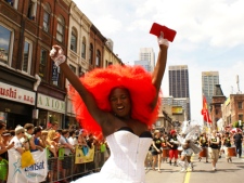 A participant in Toronto's annual Pride parade celebrates as the parade makes its way south on Yonge Street. Some estimates pegged the crowd at one million. More than 6,000 people marched or rode on floats. (CP24/Chris Kitching)
