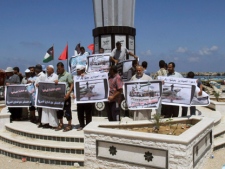 Palestinian fishermen hold placards during a protest in support of the Gaza-bound flotilla at the port in Gaza City, Tuesday, July 5, 2011. Pro-Palestinian activists say two Canadians and one Australian linked to a flotilla that seeks to leave Greece for the Gaza Strip have been detained. Arabic on the placards reads: " Gaza wait for you liberal ", " No to attack the flotilla" , " Stop the Gaza siege" , " Let the fishermen live in dignity" , " We ask the Greek government to stop the block on the flotilla". (AP Photo/Adel Hana)