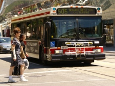 People cross the street in front of a TTC bus in this Thursday, June 30, 2011 file photo. (CP24/Chris Kitching)
