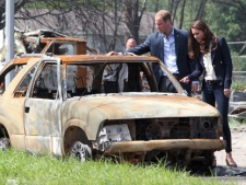 The Duke and Duchess of Cambridge look at a burned-out car in Slave Lake, Alta., on Wednesday, July 6, 2011. The couple will meet rescue workers and families who lost everything in May's devastating wildfire. (THE CANADIAN PRESS/Jonathan Hayward)
