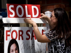 A real estate agent puts up a "sold" sign in front of a house in Toronto on Tuesday, April 20, 2010. The Canadian Real Estate Association says Canada's home prices continued to rise last month and a majority of the country's local markets showed a balance between supply and demand, including in Toronto. (THE CANADIAN PRESS/Darren Calabrese)