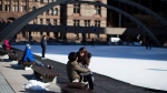 A couple enjoy a moment as they sit on the edge of the skating rink in Toronto's Nathan Phillips square on Tuesday, March 5, 2013. (The Canadian Press/Chris Young)