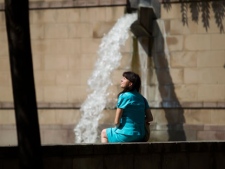 A woman sits near a fountain as a heat wave hits Toronto Thursday, July 21, 2011. According to Environment Canada, much of the hot weather is blamed on a heat dome, which has settled over parts of Canada and the United States. (THE CANADIAN PRESS/Darren Calabrese)