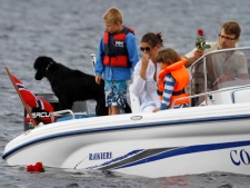A family drops red roses from their boat into the sea close to Utoya island, near Oslo, Norway, on Tuesday, July 26, 2011, where gunman Anders Behring Breivik killed at least 76 people. (AP Photo/Ferdinand Ostrop)