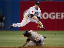 Toronto Blue Jays second baseman Aaron Hill, top, leaps over Baltimore Orioles first baseman Derrek Lee after forcing him out at second base during seventh inning AL baseball action in Toronto on Wednesday, July 27, 2011. THE CANADIAN PRESS/Nathan Denette