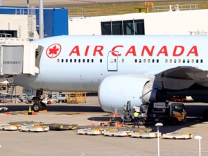 An Air Canada Boeing 777 sits at a gate after it was forced to return to Sydney Airport in Sydney, Thursday, July 28, 2011, after crew members saw smoke coming from an oven in the galley. No one on Flight AC34 was injured in the incident, which forced the pilot to dump fuel before safely landing. (AP Photo/Rick Rycroft)