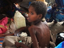 A child from southern Somalia takes food at a camp in Mogadishu, Somalia, Wednesday, Aug 3, 2011. Thousands of people have arrived in Mogadishu over the past two weeks seeking assistance and the number is increasing by the day. (AP Photo/Farah Abdi Warsameh)
