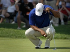 Tiger Woods crouches on the 18th green after missing a putt for par during third round play in the Bridgestone Invitational golf tournament at Firestone Country Club in Akron, Ohio on Saturday, Aug. 6, 2011. (AP Photo/Amy Sancetta)