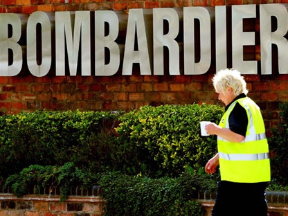 An employee walks past the company sign at the train manufacturing works of Bombardier in Derby, England Tuesday July 5, 2011. (AP / Rui Vieira)