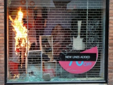 A fire is set inside a smashed shop window of a clothes store in Manchester city centre, Engalnd, Tuesday Aug. 9, 2011. Some hundreds of youths ran down the street smashing windows. (AP Photo/Dave Thompson, PA)