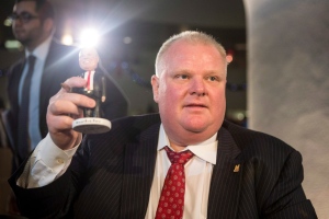 Toronto Mayor Rob Ford displays a bobble head bearing his likeness, as over 1,000 people queued at city hall to buy a signed bobblehead in Toronto on Friday, Dec. 20 2013. (The Canadian Press/Chris Young)