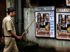 An Indian policeman stands guard outside a cinema hall screening the newly released film "Aarakshan," or "Reservation" in Mumbai, India, Friday, Aug. 12, 2011. Three Indian states have banned the movie following apprehensions that certain scenes and dialogues may trigger trouble, according to a news agency. Protestors say the film speaks against India's affirmative action program that reserves education seats and jobs for the country's indigenous peoples and its dalits, or untouchables, who have no caste and have suffered centuries of severe discrimination, and members of other lower castes. (AP Photo/Rajanish Kakade)