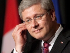 Canadian Prime Minister Stephen Harper uses a translation device as he listens to a question during a joint news conference in San Pedro Sula, Honduras Friday August 12, 2011. (THE CANADIAN PRESS/Adrian Wyld)