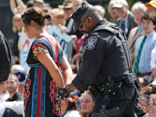 A U.S. Park Police officer handcuffs and arrests a protestor over a proposed pipeline to bring tar sands oil to the U.S. from Canada, in front of the White House in Washington, Saturday, Aug. 20, 2011. (AP Photo/Manuel Balce Ceneta)