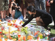 Olivia Chow, wife of NDP Leader Jack Layton, looks through mementos left by people at makeshift memorial in honour of her husband, on Parliament Hill in Ottawa, Thursday August 25, 2011. (THE CANADIAN PRESS/Fred Chartrand)