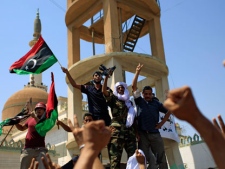 Libyans celebrate the liberation of their district of Qasr Bin Ghashir in Tripoli, LIbya, Saturday, Aug. 27, 2011. Libyan rebels claimed victory over a suburb near Tripoli's airport Saturday after an overnight battle as the opposition moves to solidify its hold on the capital while fighting Moammar Gadhafi loyalists in other parts of the country.(AP Photo/Sergey Ponomarev)