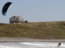 A kite surfer sails above the waves along Lawrencetown Beach near Halifax, Nova Scotia on Friday, August 26, 2011. Parts of Quebec and Atlantic Canada are bracing for the effects hurricane Irene, currently moving upwards towards the area from the American eastern seaboard. The hurricane, which is expected to be diminished in strength by the time makes landfall in Canada, will arriving late into the weekend and deliver heavy winds and rain, causing flooding in lowland coastal areas. (THE CANADIAN PRESS/Mike Dembeck)