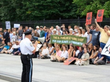 A U.S. Park Police officers speaks to demonstrators in front of the White House in Washington, Friday, Sept. 2, 2011, during a protest against the Keystone oil pipeline in the US, and the Tar Sands Development in Alberta Canada . (AP Photo/Luis M. Avarez)