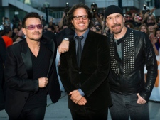 U2 lead singer Bono, left, Director Davis Guggenheim, centre, and The Edge pose for a photograph while on the red carpet before their screening of their new documentary film "From The Sky Down" at the Toronto International Film Festival in Toronto on Thursday, Sept. 8, 2011. (THE CANADIAN PRESS/Nathan Denette)