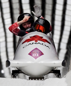 The team from Canada CAN-1, piloted Kaillie Humphries with brakeman Heather Moyse, cross into the finish area to win the gold medal in the women's bobsled competition Wednesday, Feb. 19, 2014, in Krasnaya Polyana, Russia. (AP Photo/Michael Sohn)