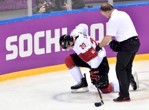 Canada forward John Tavares is helped off the ice after sustaining an injury during second period quarter-final hockey action against Latvia at the 2014 Sochi Winter Olympics in Sochi, Russia, on Wednesday, Feb. 19, 2014. (The Canadian Press/Nathan Denette)