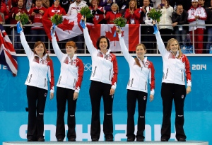 Canada's women's curling team, as seen from left to right, Kirsten Wall, Dawn McEwen, Jill Officer, Kaitlyn Lawes and skip Jennifer Jones, celebrate during the flower ceremony after winning the gold medal game against Sweden at the 2014 Winter Olympics Thursday, Feb. 20, 2014, in Sochi, Russia. (AP Photo/Wong Maye-E)
