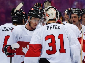 Canada forward Jonathan Toews congratulates Canada goaltender Carey Price after Canada's 2-1 win over Latvia during a men's quarterfinal ice hockey game at the 2014 Winter Olympics on Wednesday, Feb. 19, 2014, in Sochi, Russia. (AP Photo/Julio Cortez)