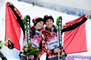 Women's skicross gold medallist Marielle Thompson of Canada, right, celebrates on the podium with silver medallist and compatriot Kelsey Serwa at the Rosa Khutor Extreme Park at the 2014 Winter Olympics Friday, Feb. 21, 2014, in Krasnaya Polyana, Russia. (AP Photo/Andy Wong)