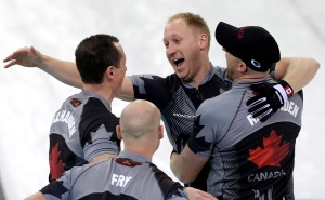 Canada's men's curling team, as seen clockwise, Brad Jacobs, Ryan Harnden, Ryan Fry and E.J. Harnden, celebrate after beating Britain to win the men's curling gold medal game at the 2014 Winter Olympics on Friday, Feb. 21, 2014, in Sochi, Russia. (AP Photo/Wong Maye-E)