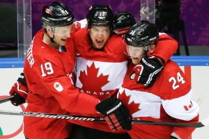Canada forward Benn Jamie, centre, celebrates his goal against the U.S. with teammates Jay Bouwmeester, left, and Corey Perry, right, during the second period of the men's semifinal ice hockey game at the 2014 Winter Olympics Friday, Feb. 21, 2014, in Sochi, Russia. (AP Photo/Mark Humphrey)