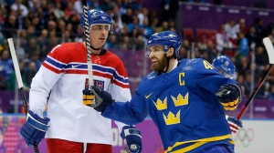 Sweden forward Henrik Zetterberg, right, reacts in front of Czech Republic defenseman Tomas Kaberle after Sweden scored a goal in the second period of a men's ice hockey game at the 2014 Winter Olympics, Wednesday, Feb. 12, 2014, in Sochi, Russia. (AP Photo/Mark Humphrey)