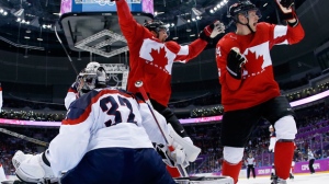 Canada forward Benn Jamie, left, reacts after scoring a goal in front of USA goaltender Jonathan Quick of a men's semifinal ice hockey game at the 2014 Winter Olympics, Friday, Feb. 21, 2014, in Sochi, Russia. (AP Photo/Julio Cortez, Pool)