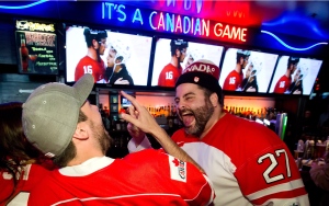 Fans celebrate at the Shark Club sports bar in Vancouver, on Friday February 21, 2014, after the Canadian Olympic men's hockey team defeated the U.S. 1-0 in the semi-final at the Sochi Winter Olympics and advanced to the gold medal game. (Darryl Dyck/The Canadian Press)