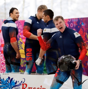 The team from Russia RUS-1, with Alexander Zubkov, foreground, Alexey Negodaylo, Dmitry Trunenkov, and Alexey Voevoda, react after their third run during the men's four-man bobsled competition final at the 2014 Winter Olympics, Sunday, Feb. 23, 2014, in Krasnaya Polyana, Russia. (AP Photo/Jae C. Hong)