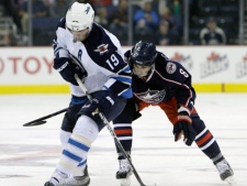 Winnipeg Jets' Jim Slater, left, and Columbus Blue Jackets' Maksim Mayorov, of Russia, fight for a loose puck during the first period of an NHL preseason hockey game Tuesday, Sept. 20, 2011, in Columbus, Ohio. (AP Photo/Jay LaPrete)