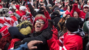 Hockey fans celebrate in Toronto's Maple Leaf Square after the final buzzer as Canada beat Sweden 3-0 to win the gold medal in the men's Olympic Hockey Final on Feb. 23, 2014. (The Canadian Press/Chris Young)