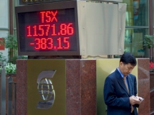 An unidentified man stands next to a board showing the drop in the TSX index in Toronto's financial district on Thursday September 22, 2011. (THE CANADIAN PRESS/Chris Young)