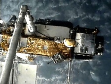 This screen grab image provided by NASA shows UARS attached to the robotic arm of the space shuttle Discovery during mission STS-48 in 1991, when UARS was deployed. NASA scientists are doing their best to tell us where a plummeting 6-ton satellite will fall later this week. It's just that if they're off a little bit, it could mean the difference between hitting Florida or New York. Or, say, Iran or India. (AP Photo/NASA) 