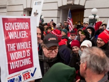Filmmaker Michael Moore, center, makes his way through a crowd at the state Capitol in Madison, Wis., Saturday, March 5, 2011, on the 18th day of protests over the governor's proposed budget that would eliminate collective bargaining rights for many state workers. (AP Photo/Andy Manis)